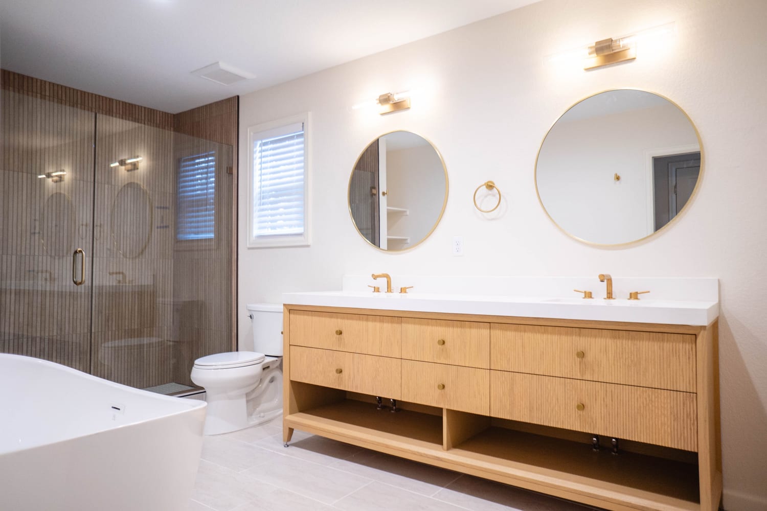 Finished primary bathroom with a double vanity and walk-in shower